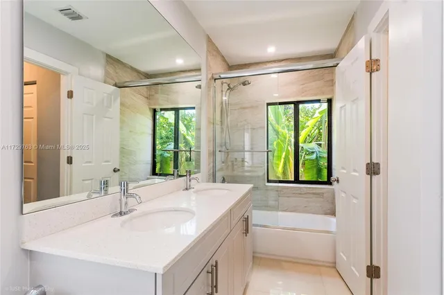 a bathroom with a tub sink and mirror