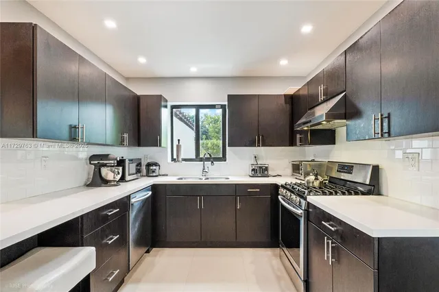 a kitchen with stainless steel appliances a sink stove and cabinets