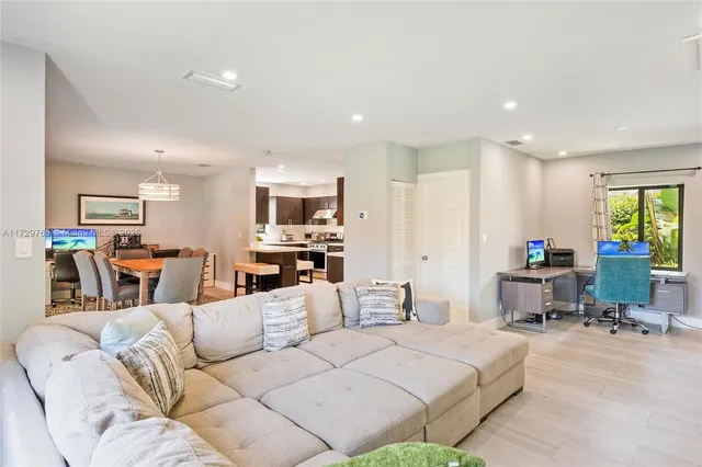a living room with furniture and a dining table with kitchen view