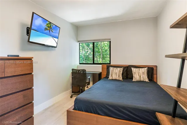 a large bed sitting in a bedroom next to a window