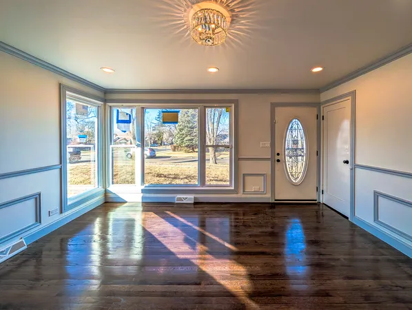 a living room with hardwood floor and a large window