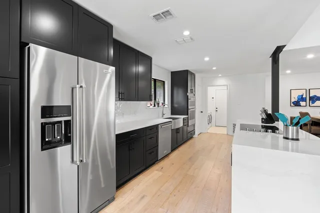 a kitchen with stainless steel appliances a refrigerator and a sink