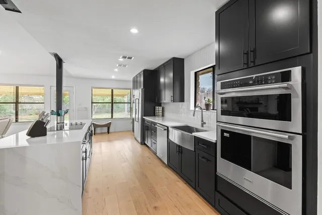 a kitchen with stainless steel appliances kitchen island granite countertop a stove and a sink
