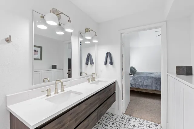 a en suite bathroom with a double vanity sink a mirror and a