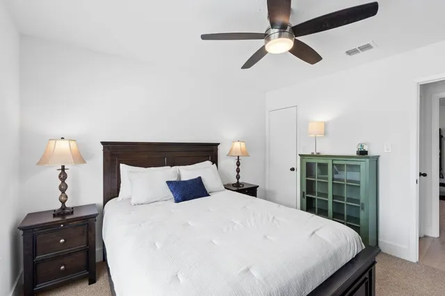 a bedroom with a bed and a ceiling fan