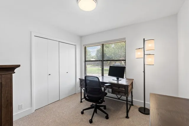 a view of a workspace with furniture and a window