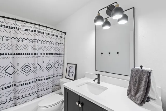 a bathroom with a sink a toilet and a mirror