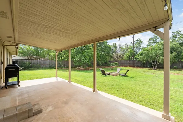 a view of swimming pool with lawn chairs and a big yard