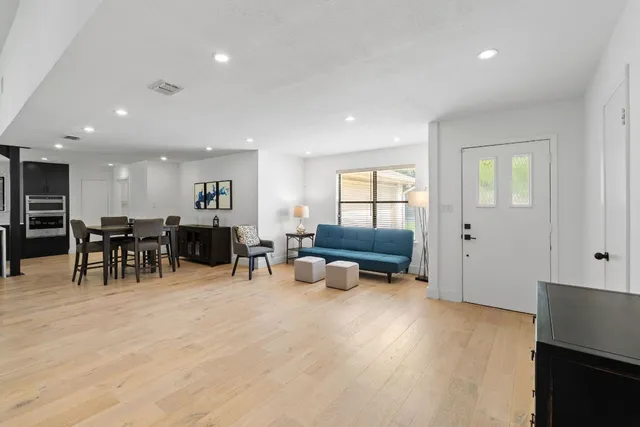 a living room with furniture and a wooden floor