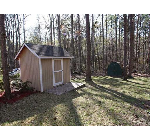7933 Brandyapple Drive Raleigh, NC 27615 - Photo 10 of 12 Storage shed for all the extra stuff and the lawn care equipment.