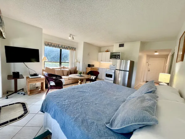 a living room with furniture a flat screen tv and a large window