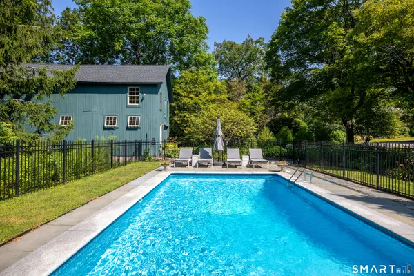a view of a house with pool and a yard