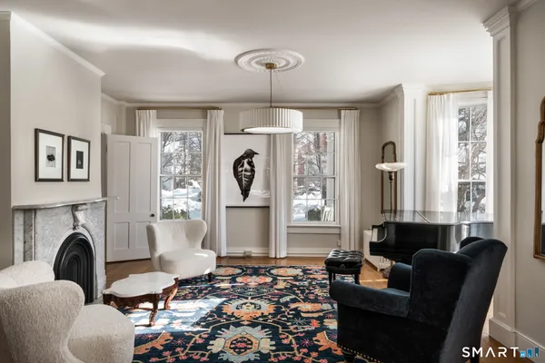 a living room with furniture a fireplace and a chandelier