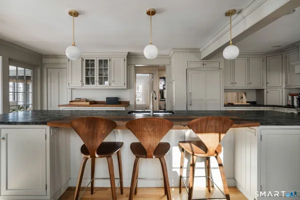 a kitchen with a dining table chairs and cabinets