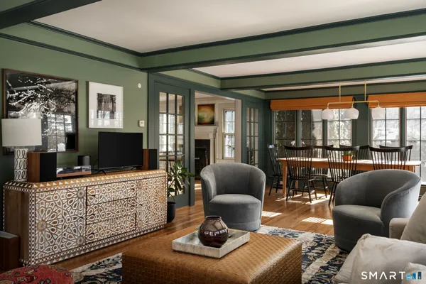 a living room with furniture a flat screen tv and a large window