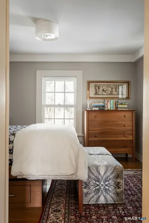 a bed sitting in a bedroom next to a window