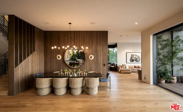 a living room with couches and a flat screen tv with kitchen view