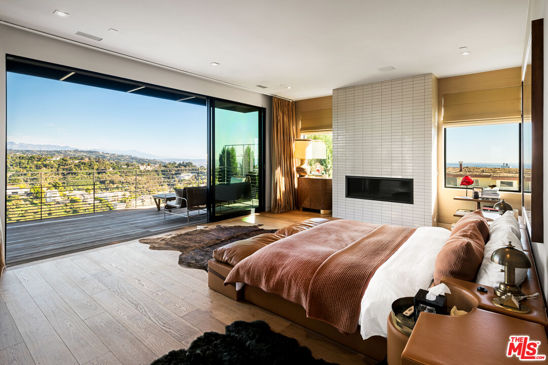 1030 Somera Road Los Angeles, CA 90077 - Photo 29 of 54 a bedroom with a bed and large windows