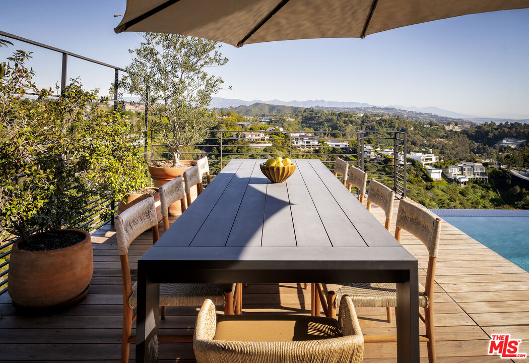 1030 Somera Road Los Angeles, CA 90077 - Photo 48 of 54 a view of a balcony with two chairs and a potted plant