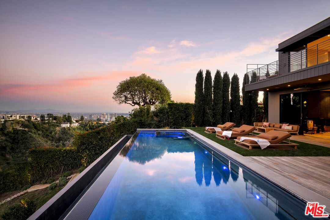 1030 Somera Road Los Angeles, CA 90077 - Photo 49 of 54 a view of swimming pool with seating area and green space