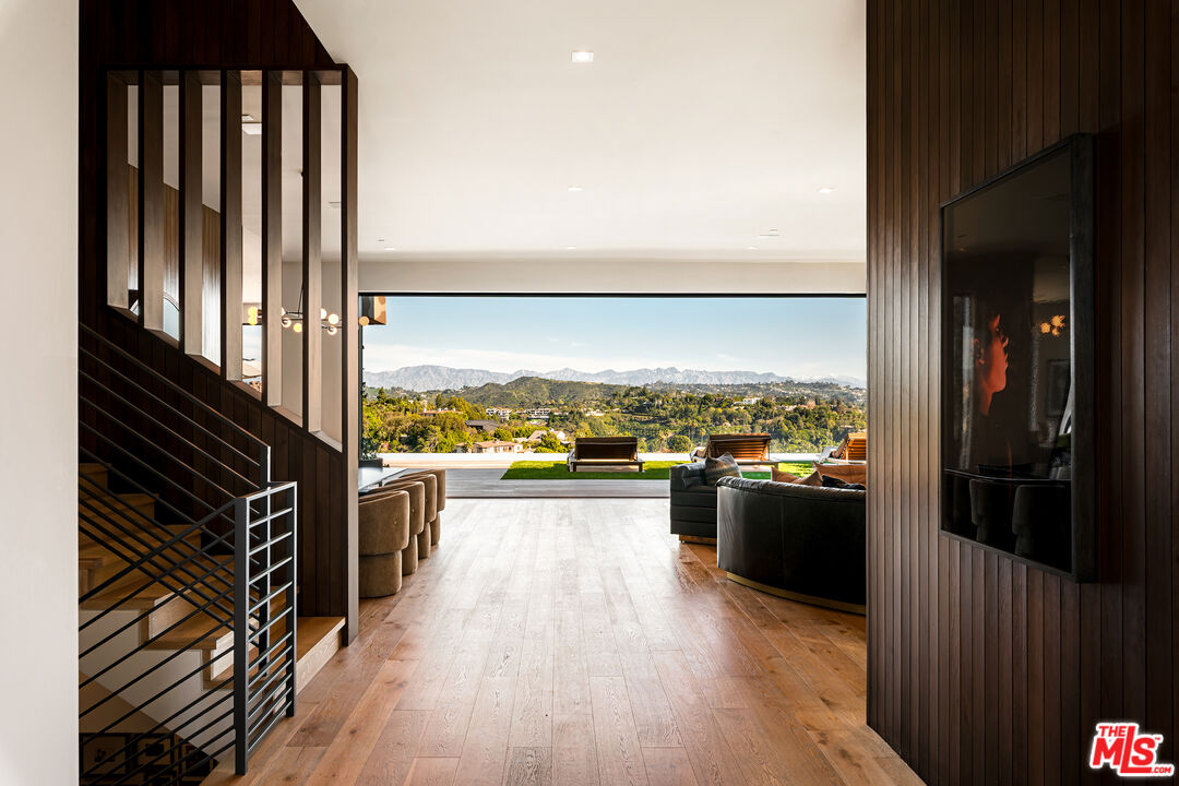 1030 Somera Road Los Angeles, CA 90077 - Photo 5 of 54 a view of a living room with kitchen view and a wooden floor