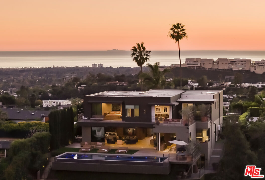 1030 Somera Road Los Angeles, CA 90077 - Photo 54 of 54 a front view of a house with a garden and lake view