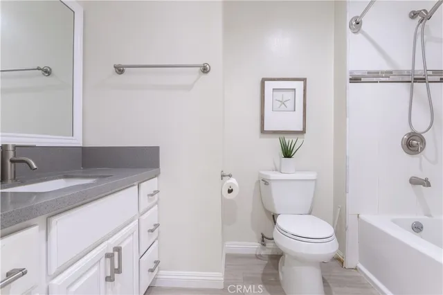 a bathroom with a granite countertop sink a toilet and shower
