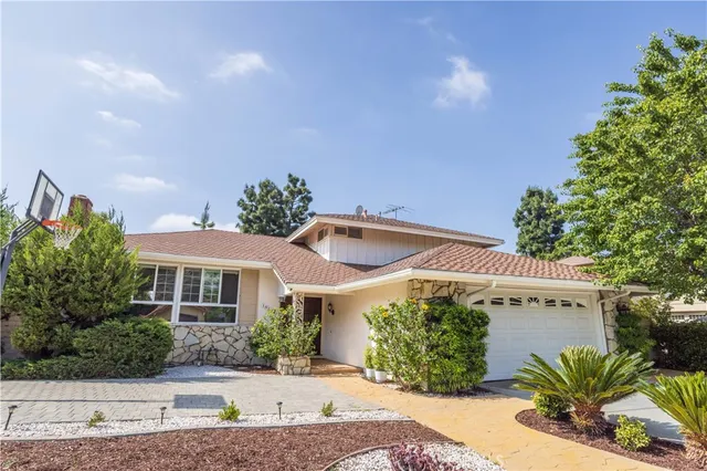 a front view of a house with a yard and potted plants