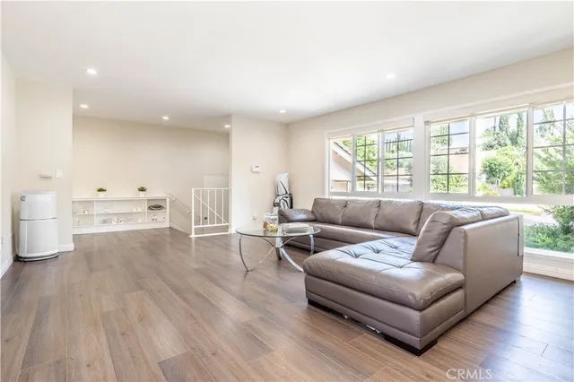 a living room with furniture and a large window with kitchen view