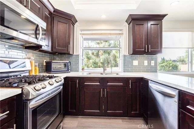 a kitchen with stainless steel appliances granite countertop wooden cabinets stove top oven and sink