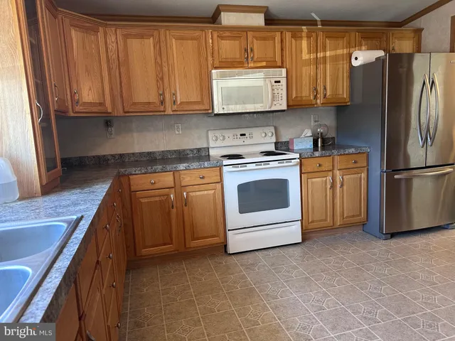 a kitchen with stainless steel appliances granite countertop a stove a refrigerator and a microwave