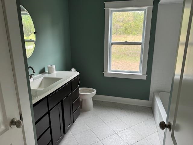 1020 Pine Top Road Toone, TN 38381 - Photo 13 of 16 Bathroom featuring a dark wood-finish vanity with a white countertop and integrated sink, a rectangular window with white trim, and light-colored square floor tiles
