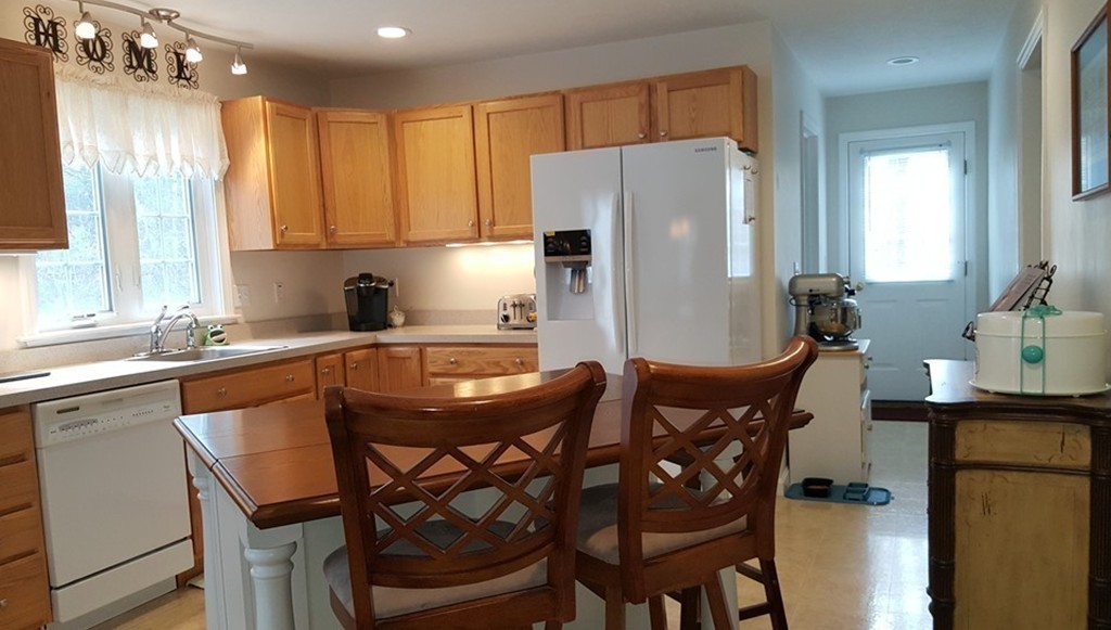 5 Hazen Road Shirley, MA 01464 - Photo 4 of 23 a kitchen with stainless steel appliances granite countertop a dining table chairs and a refrigerator