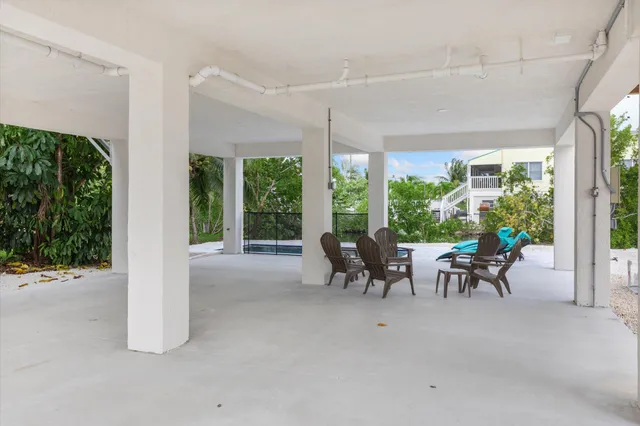 a view of a porch with chairs and floor to ceiling window