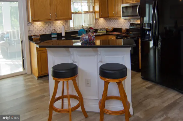 a kitchen with stainless steel appliances a stove a sink a microwave and cabinets