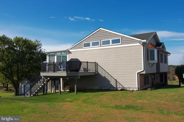 a view of a house with a big yard and large trees