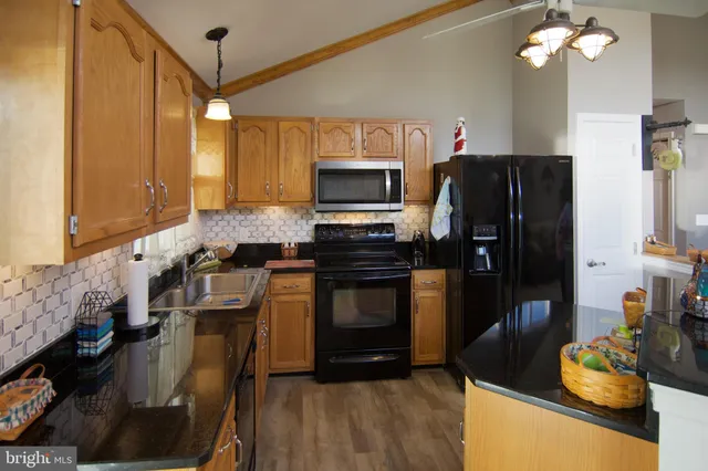 a kitchen with granite countertop stainless steel appliances and wooden cabinets
