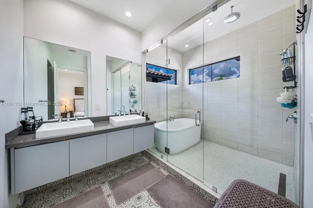 a white bath tub sitting next to a white sink and vanity