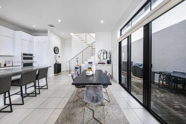 a living room with stainless steel appliances kitchen island granite countertop a table chairs and a view of living room