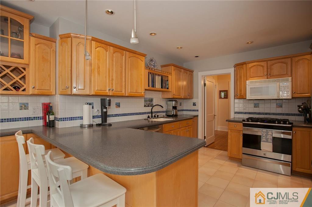 9 Lenox Street Edison, NJ 08817 - Photo 13 of 23 a kitchen with stainless steel appliances granite countertop a stove a sink a microwave and a refrigerator