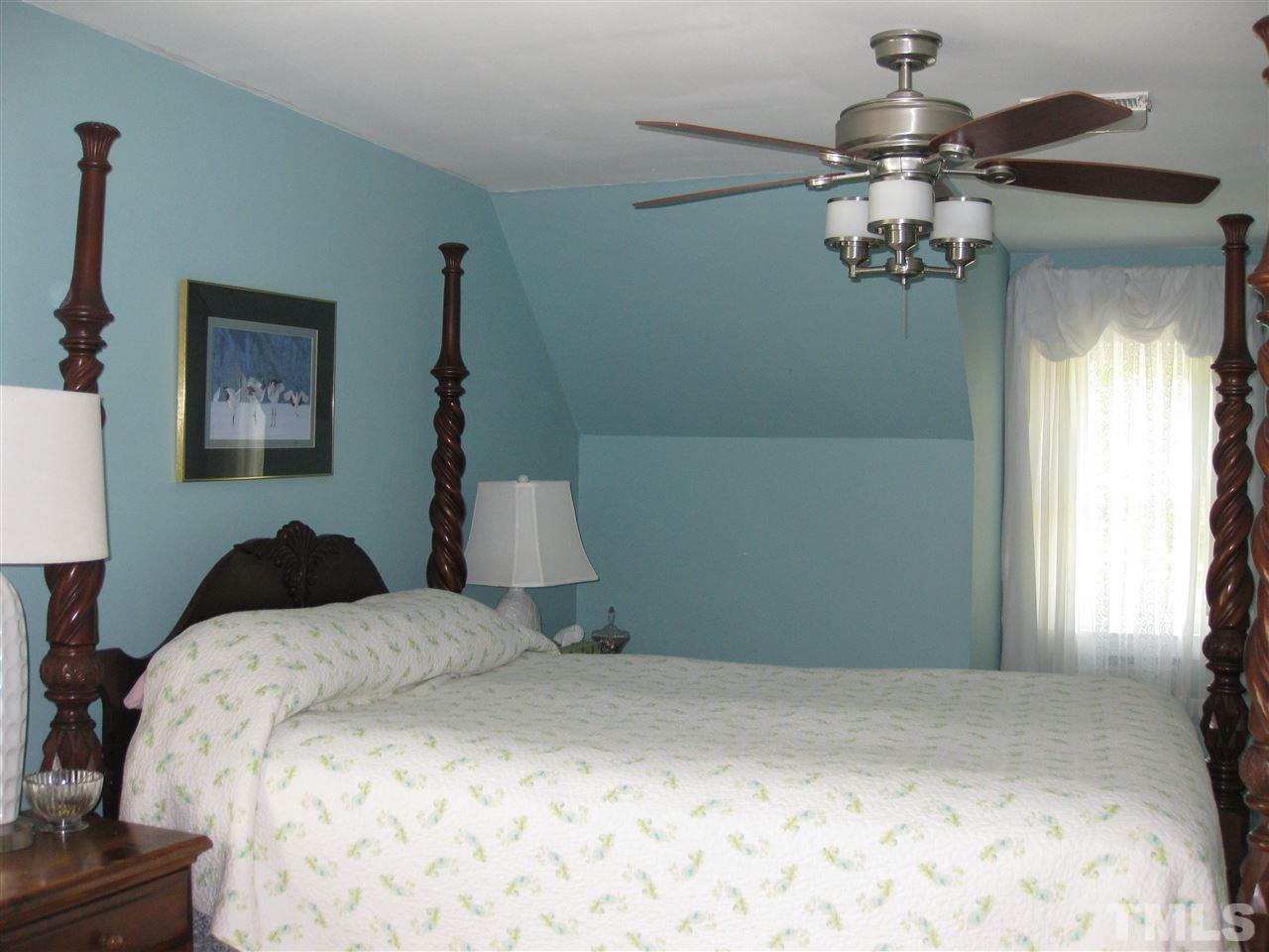 6523 Wynbrook Way Raleigh, NC 27612 - Photo 12 of 21 a bedroom with a bed and a chandelier