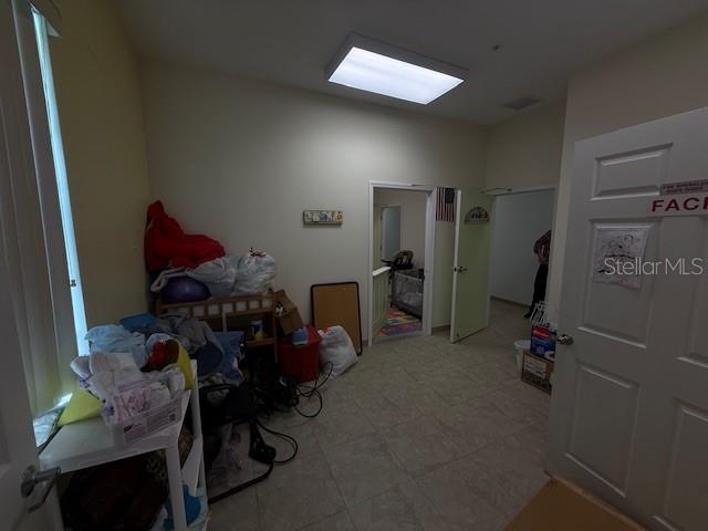 8826 Trevarthon Road Orlando, FL 32817 - Photo 51 of 57 a room with gym equipment and a chandelier