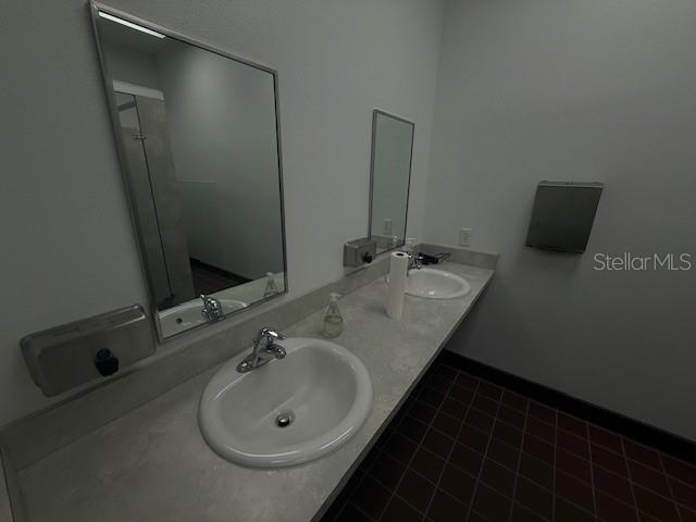 8826 Trevarthon Road Orlando, FL 32817 - Photo 54 of 57 a bathroom with a double vanity sink and a mirror