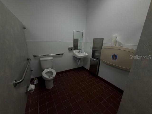 8826 Trevarthon Road Orlando, FL 32817 - Photo 56 of 57 a bathroom with a toilet and a sink