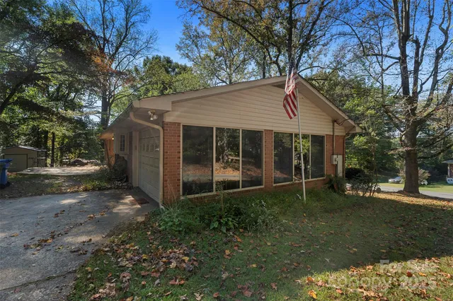 a view of a house with a yard and large tree
