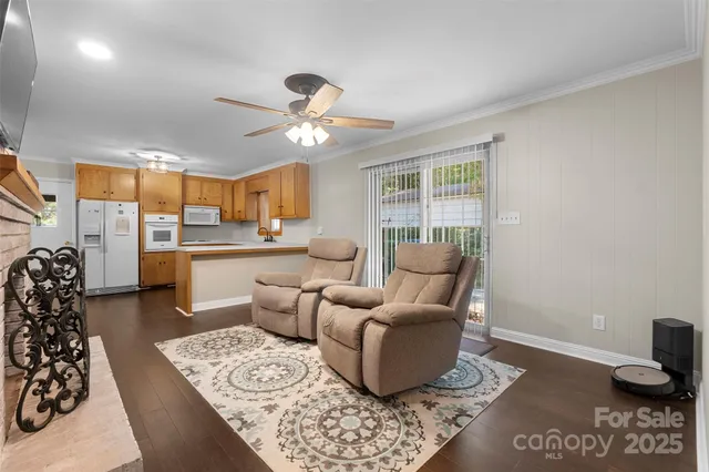 a living room with furniture a rug and kitchen view