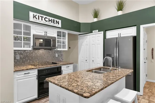 a kitchen with stainless steel appliances granite countertop a refrigerator and a stove top oven