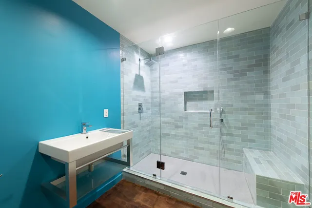 a bathroom with a shower a mirror and a sink