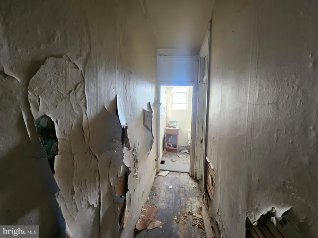 a view of a hallway with wooden floor and entryway