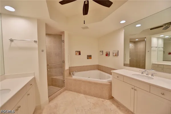 a bathroom with a tub a sink and a large mirror